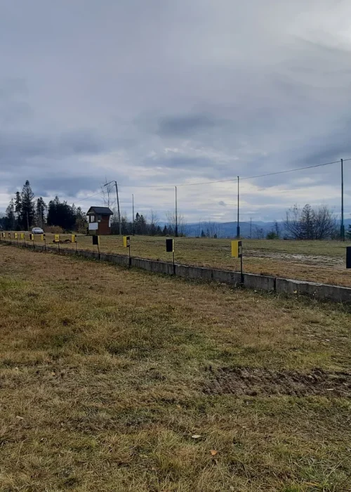 Geodeta GEO-GRAF wykonujący pomiary kontrolne na terenie strzelnicy biathlonowej.